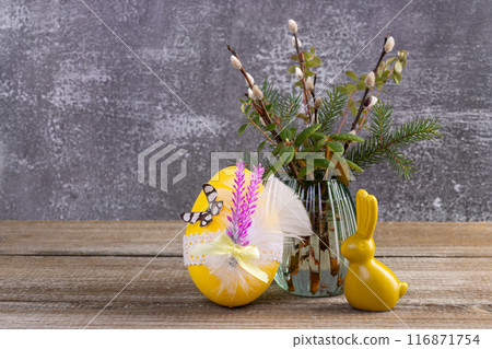 Wooden table with Easter bunny, egg and bunch of willow. Wooden table with Easter bunny, egg and bunch of willow. 116871754