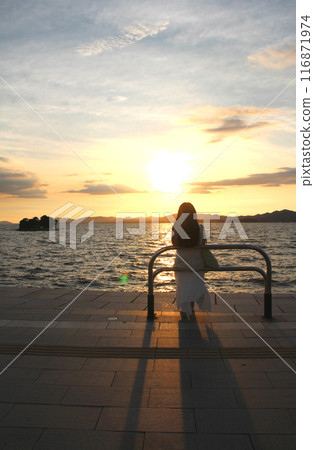 Woman enjoying the sunset by the lake Woman enjoying the sunset by the lake 116871974
