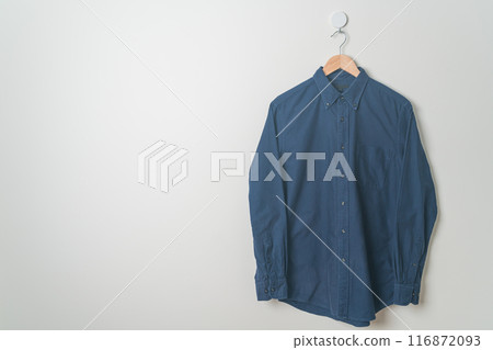 hanging shirt with wood hanger on wall 116872093