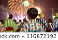A boy in a yukata looking up at fireworks 116872192