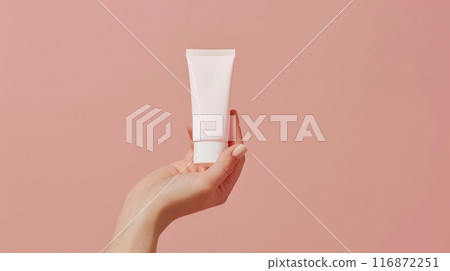 Hand holding cream tube with soft pastel background for beauty and skincare advertisement Hand holding cream tube with soft pastel background for beauty and skincare advertisement 116872251