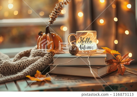 lightbox with the text Hello Autumn, on top of books, autumn decorations and a coffee mug in the background lightbox with the text Hello Autumn, on top of books, autumn decorations and a coffee mug in the background 116873113