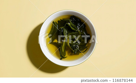 Green tea leaves background pastel yellow 116878144