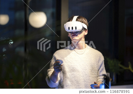 戴著 VR 護目鏡手持控制器的年輕人 116878591