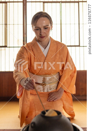 A foreign woman in a kimono performing a tea ceremony A foreign woman in a kimono performing a tea ceremony 116878777