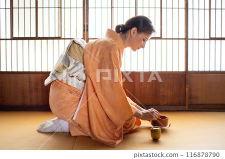 A foreign woman in a kimono performing a tea ceremony 116878790