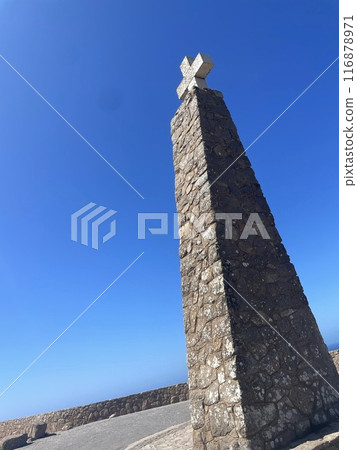 A monumental cross towering against the blue sky A monumental cross towering against the blue sky 116878971