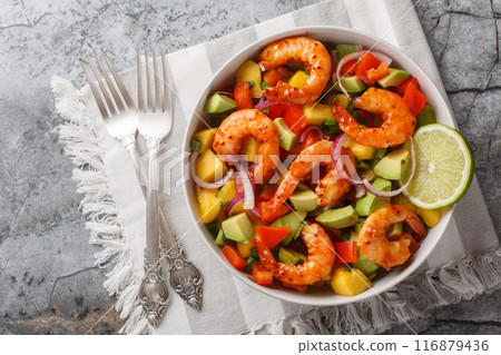 Delicious sweet and sour mango shrimp salad with red onion, bell pepper and avocado close-up in a bowl. Horizontal top view Delicious sweet and sour mango shrimp salad with red onion, bell pepper and avocado close-up in a bowl. Horizontal top view 116879436