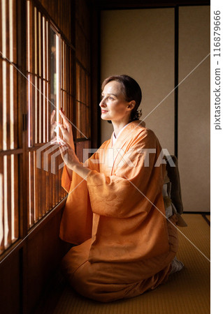 A foreign woman in a kimono sitting in front of a shoji screen 116879666