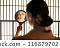 一位身穿和服的外國女子在障子屏風前看著手鏡 116879702