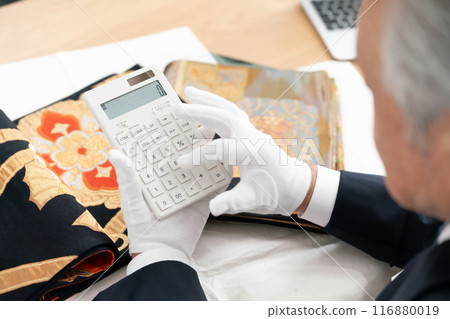 Man assessing recycling, calculator in hand Man assessing recycling, calculator in hand 116880019