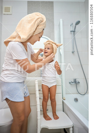 Happy mom puts a towel on girl kid head. 116880504