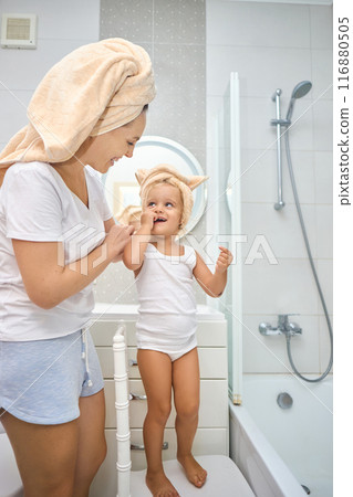 Happy mom puts a towel on girl kid head. 116880505