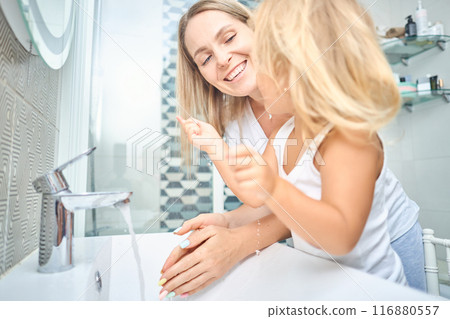 mother and child washing their faces together in the bathroom mother and child washing their faces together in the bathroom 116880557
