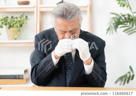 一名男子用放大鏡進行評估 116880817