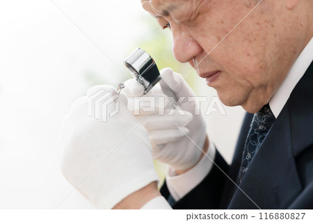 A man examining something with a magnifying glass 116880827