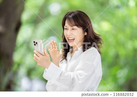 一個操作智能手機的女人，新鮮的綠色 116882032