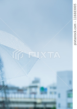 A middle-aged woman holding an umbrella in the pouring rain A middle-aged woman holding an umbrella in the pouring rain 116883005