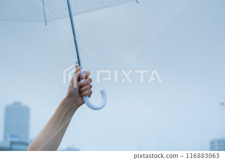 A middle-aged woman holding an umbrella in the pouring rain A middle-aged woman holding an umbrella in the pouring rain 116883063