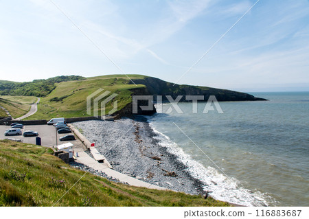A coastline of gravel and a cove with cliffs formed by seawater erosion. On the outskirts of South Wales. 116883687