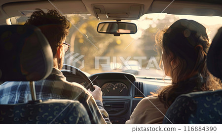 view from the back seat of a car, with a man driving and a woman sitting in the passenger seat 116884390