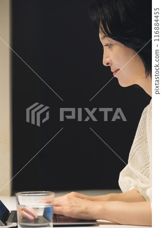 晚上用電腦工作的中年婦女 晚上用電腦工作的中年婦女 116884455