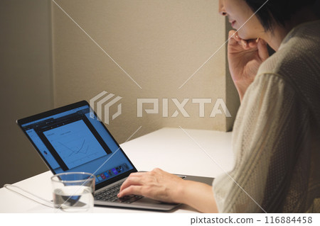 晚上用電腦工作的中年婦女 晚上用電腦工作的中年婦女 116884458