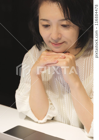 晚上用電腦工作的中年婦女 晚上用電腦工作的中年婦女 116884478