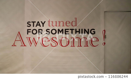 Big under construction cover poster for a renovation shop says Stay tuned for something awesome, and a small door to get in. Big under construction cover poster for a renovation shop says Stay tuned for something awesome, and a small door to get in. 116886244