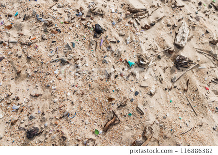 Microplastic rubbish on coastline. Plastic garbage in sand on ocean beach. 116886382