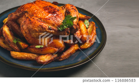 Fried whole chicken, with potatoes, on a gray background, no people. 116886583