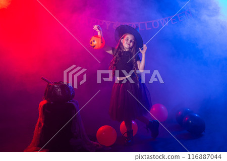 Happy laughing child girl in witch costume to Halloween holds jack lantern, copy space 116887044