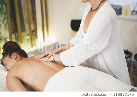 Process of back massage in spa salon. Masseur's hands gently slide over the clients skin, selective focus. Process of back massage in spa salon. Masseur's hands gently slide over the clients skin, selective focus. 116887170