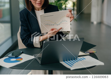 A businesswoman analyzes data and presents growth charts, showing leadership and professionalism 116889063
