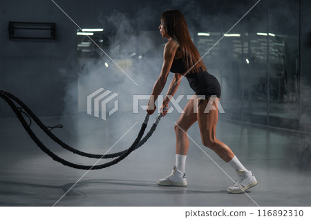 Caucasian woman doing exercise with ropes. Caucasian woman doing exercise with ropes. 116892310