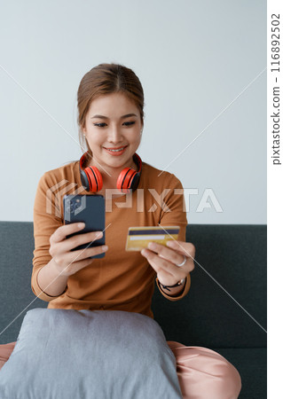 The woman uses her credit card to make online purchases, browsing various stores on her smartphone mobile The woman uses her credit card to make online purchases, browsing various stores on her smartphone mobile 116892502