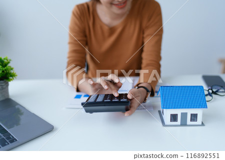 Woman Home Finance Management using calculator, computer and documents Mortgage to plan calculate Woman Home Finance Management using calculator, computer and documents Mortgage to plan calculate 116892551