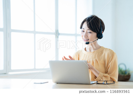 Middle woman having an online meeting in the living room 116893561