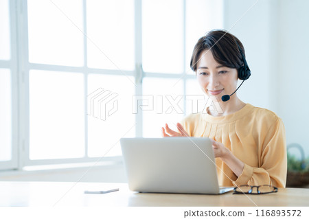 Middle woman having an online meeting in the living room 116893572