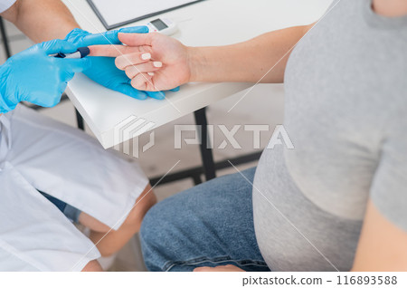 The doctor checks the blood sugar level of a pregnant patient. Gestational diabetes.  116893588
