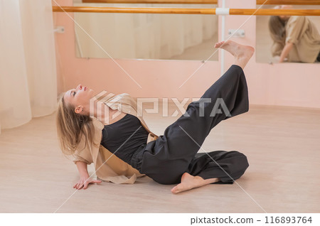 Caucasian woman dancing contemporary on the floor in a ballet class.  Caucasian woman dancing contemporary on the floor in a ballet class.  116893764