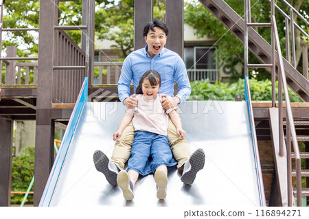 Parents and daughters playing on a slide 116894271