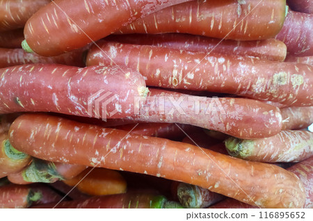 Stack of red carrots on a market stall Stack of red carrots on a market stall 116895652