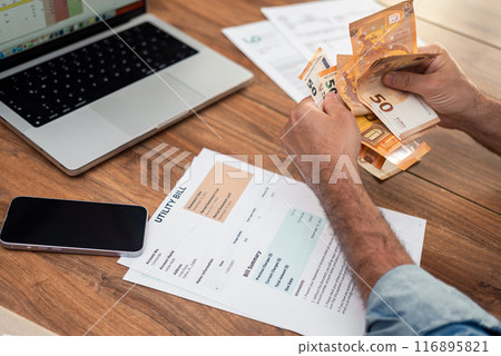Mature businessman counts euros bills processing utility bills at office table, middle aged company accountant prepares financial expenses for household services 116895821