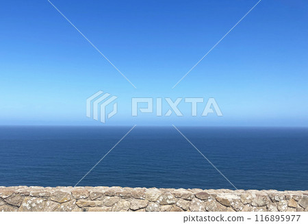 Stone wall, blue sky and sea horizon Stone wall, blue sky and sea horizon 116895977