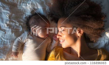 Mother and baby lying on bed with loving expressions. Cozy family moment showcasing early motherhood and bonding. 116896083