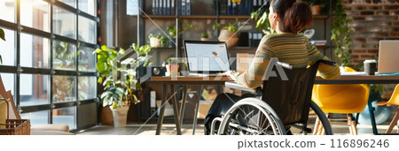 Woman in a wheelchair working on a laptop in a bright, modern office. Focus on accessibility and technology. Woman in a wheelchair working on a laptop in a bright, modern office. Focus on accessibility and technology. 116896246