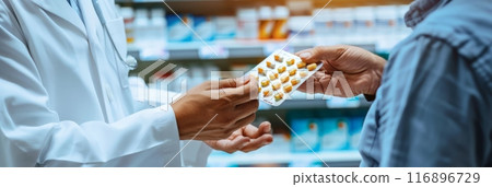 Doctor handing blister pack of yellow capsules to customer in a pharmacy. Healthcare, patient care, and medication dispensing. Doctor handing blister pack of yellow capsules to customer in a pharmacy. Healthcare, patient care, and medication dispensing. 116896729