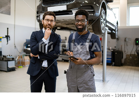 Mechanic and businessman in discussion at auto repair shop 116897015