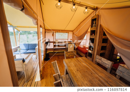 Interior of cozy open glamping tent. Camping tent for outdoor summer holiday and vacation 116897814